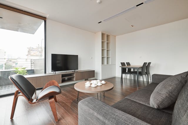 a living room with grey couch and round coffee table